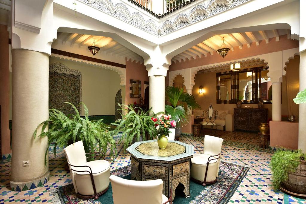 a lobby with a table and chairs in a building at Riad Manissa in Marrakesh