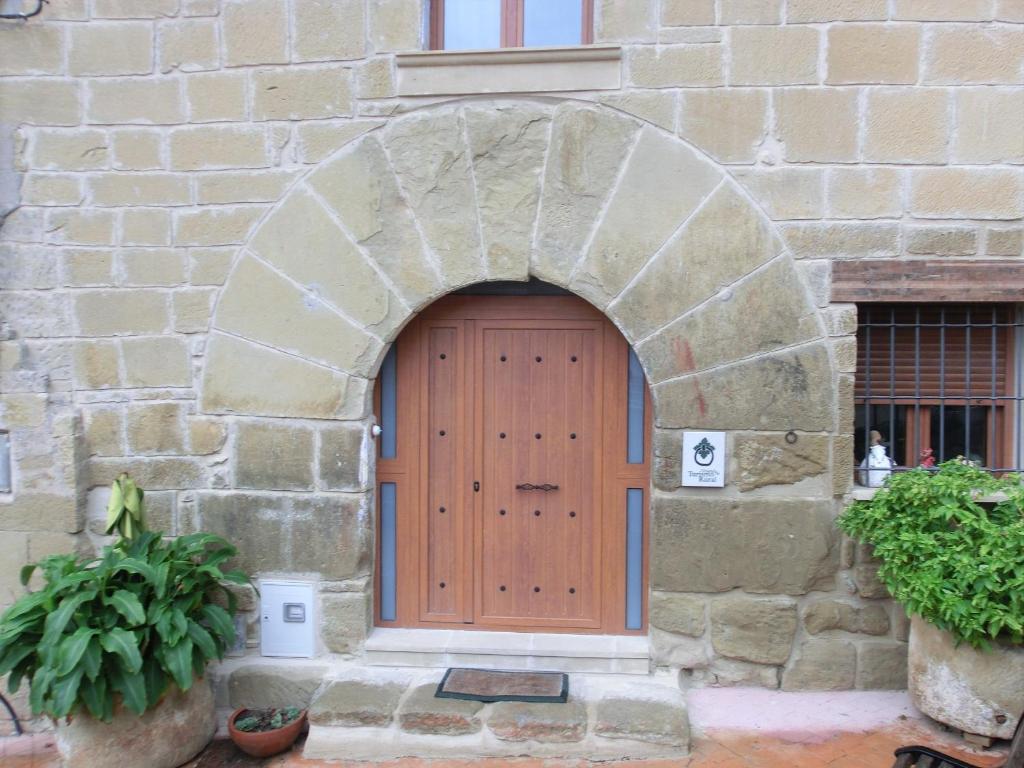 a wooden door in a stone building with an arch at Natura Jordan in Murillo de Gállego