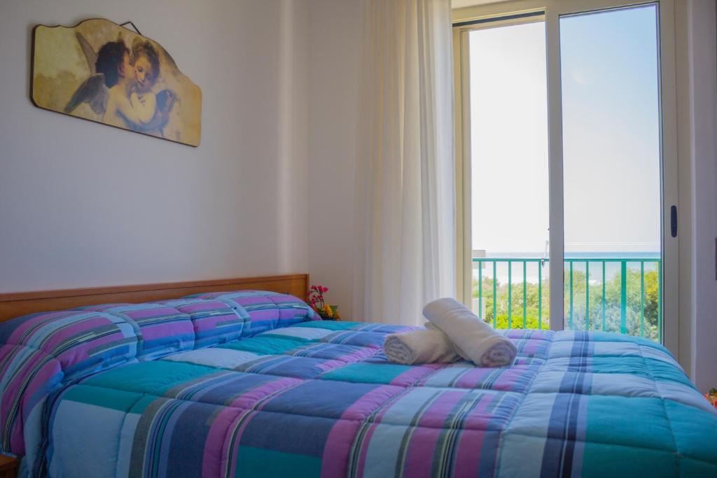 a bed in a room with a window and a bed sidx sidx sidx at Punta Di Mola in Marina di Ragusa