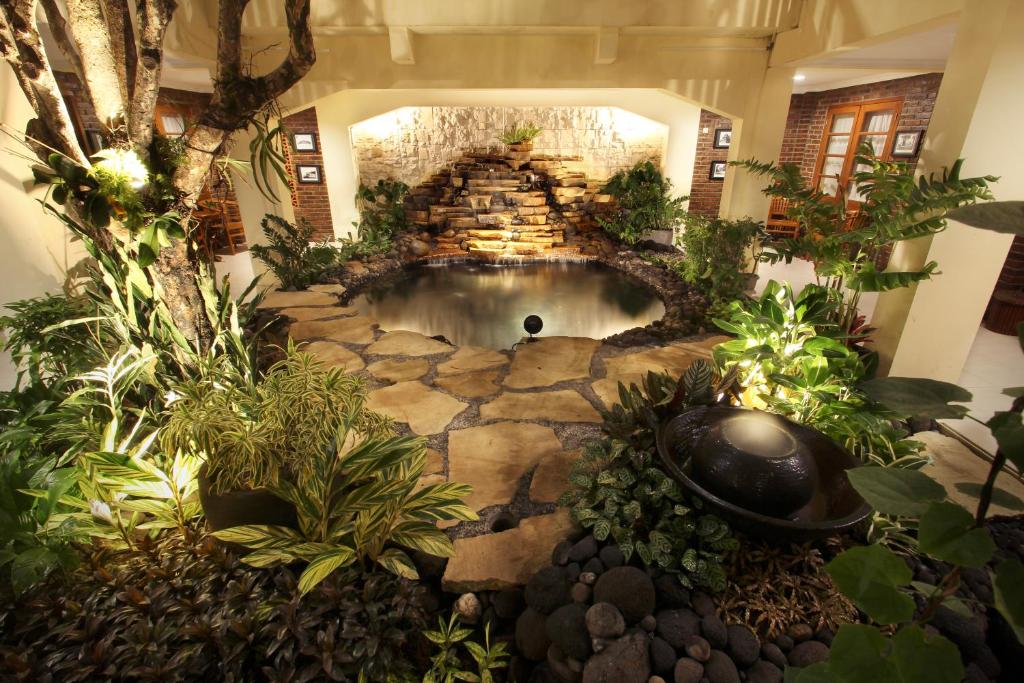 an indoor garden with a waterfall in a building at De Hostel Yogyakarta in Yogyakarta
