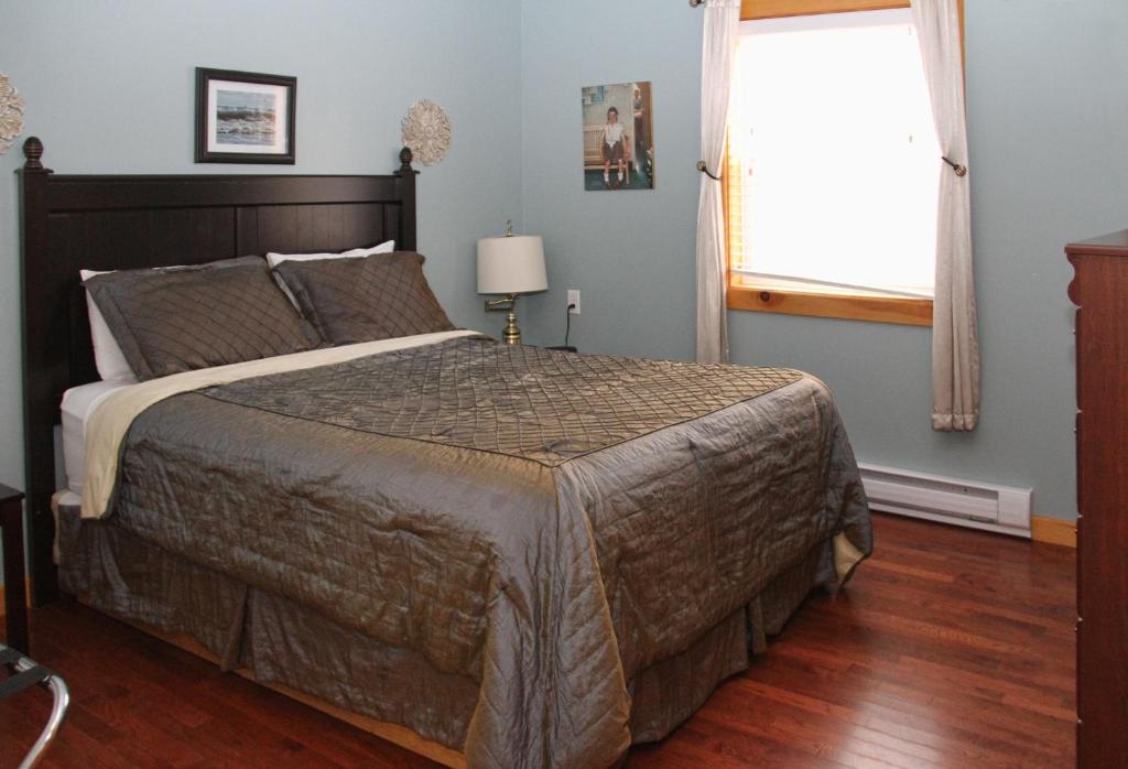 a bedroom with a large bed and a window at Mackenzie Motel & Cottages in Shelburne