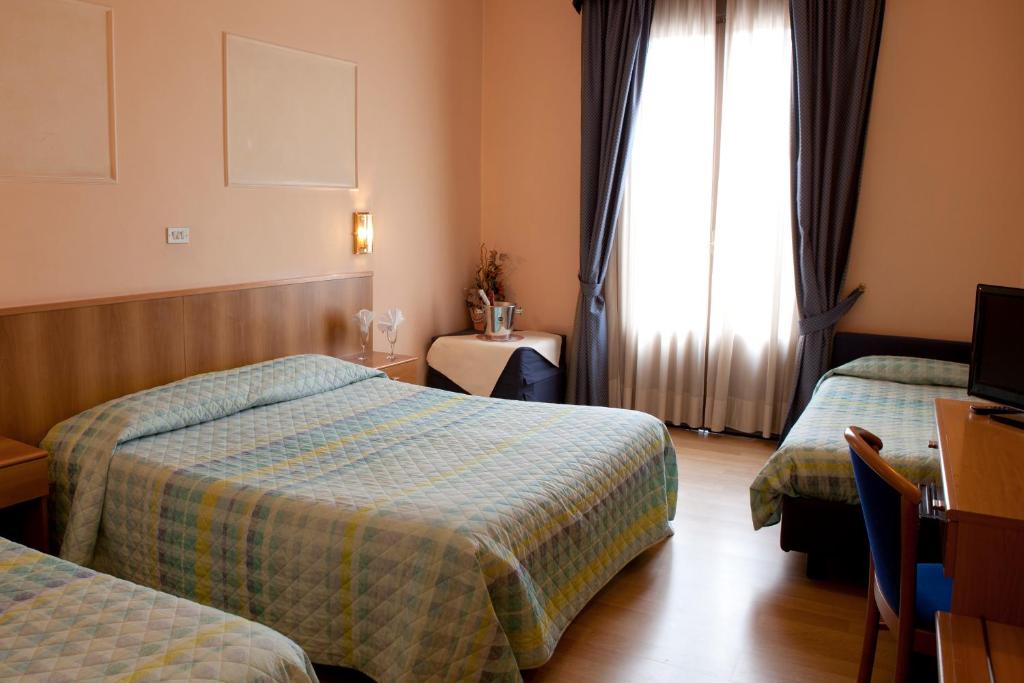 Łóżko lub łóżka w pokoju w obiekcie Hotel Porziuncola