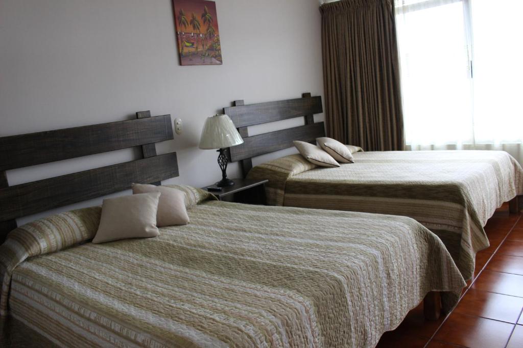 Postel nebo postele na pokoji v ubytování Hotel Arenal by Regina