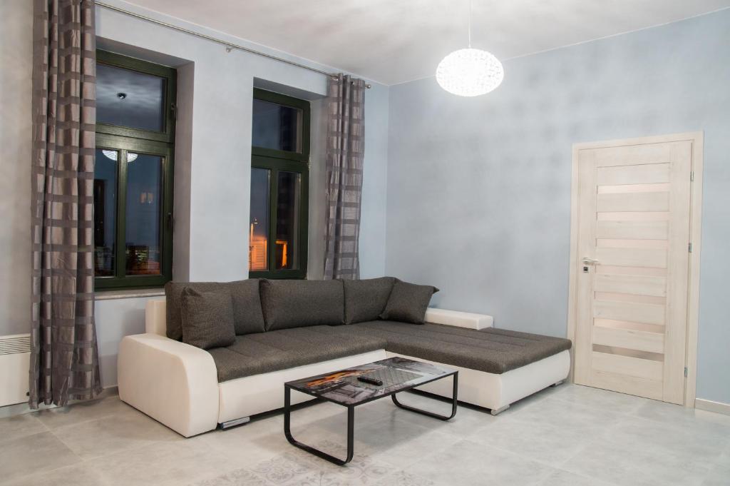uma sala de estar com um sofá e uma mesa em Apartamenty BOJAR em Mikolajki