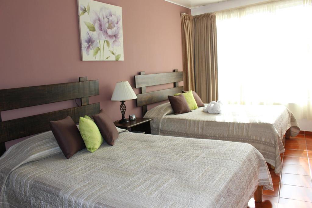 Postel nebo postele na pokoji v ubytování Hotel Arenal by Regina