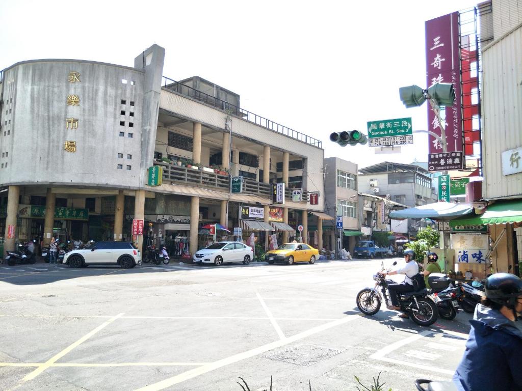 a man riding a motorcycle on a city street at EasyInn Hotel &amp; Hostel in Tainan