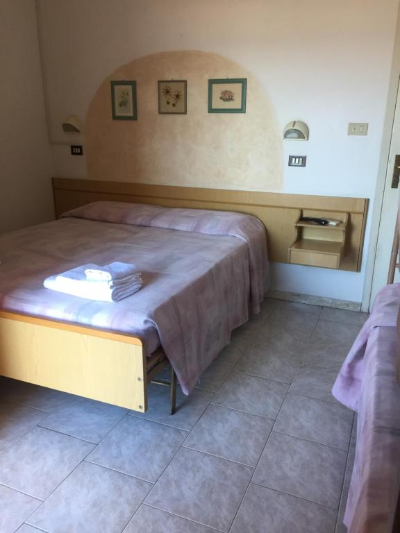 a bedroom with a bed with a table in it at Albergo Maria Luisa in Rimini