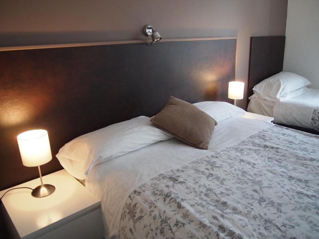 a bedroom with a large bed with two lamps at Kingswood Hotel in Maidenhead