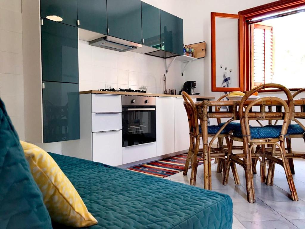 a kitchen with green cabinets and a table and chairs at Casa MareLuna in San Vito lo Capo
