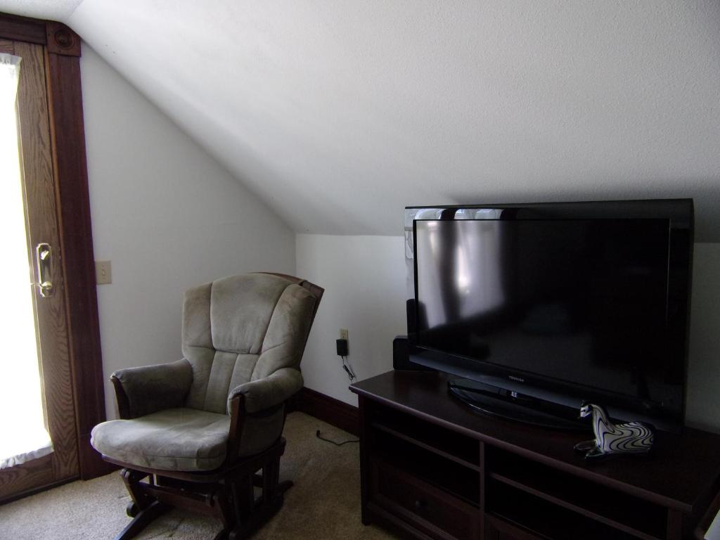 uma sala de estar com uma cadeira e uma televisão de ecrã plano em Country Diamond em Sidney