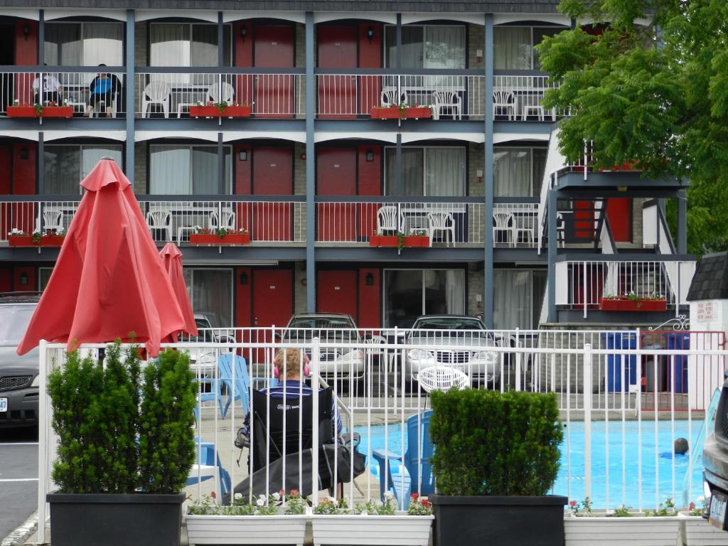 a building with a pool and a red umbrella at Kings Inn Near the Falls in Niagara Falls