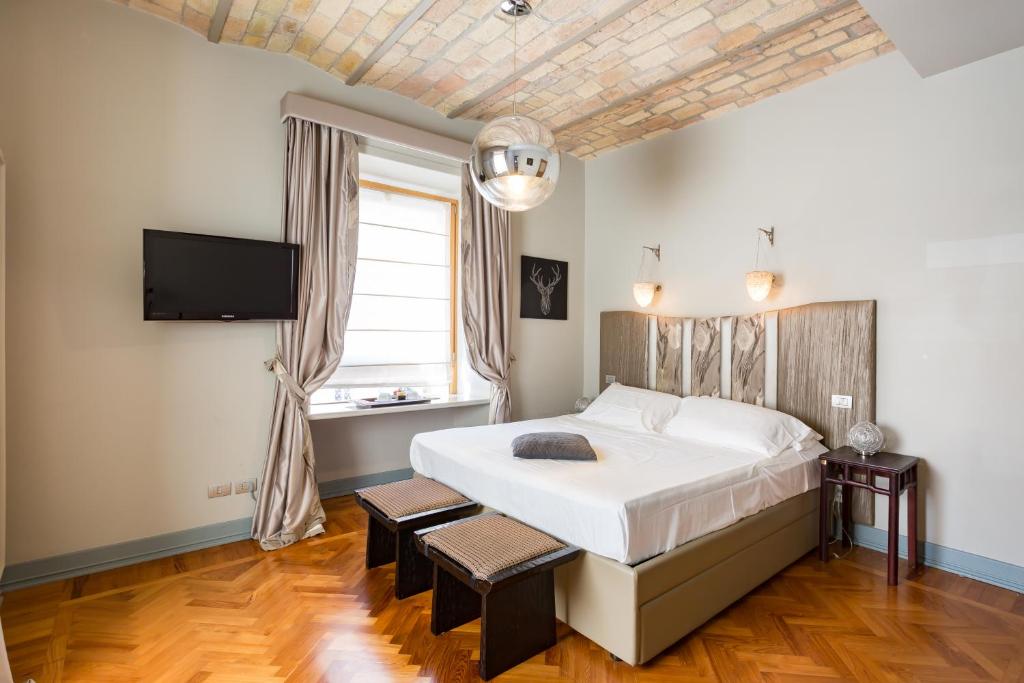 a bedroom with a large bed and a flat screen tv at Rooms Roma - Monti in Rome