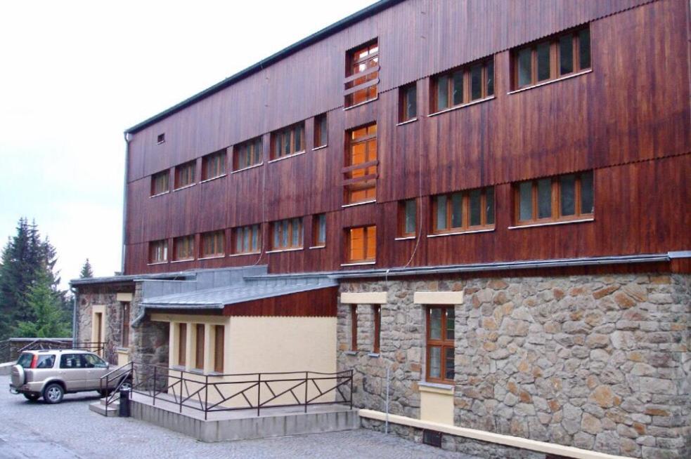 ein Gebäude mit einem davor geparkt in der Unterkunft Apartmán Bílý Kříž in Staré Hamry