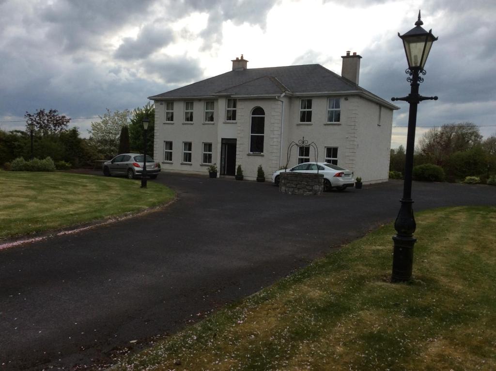 una casa blanca con una luz de la calle delante de ella en Keyfield House, en Mullingar