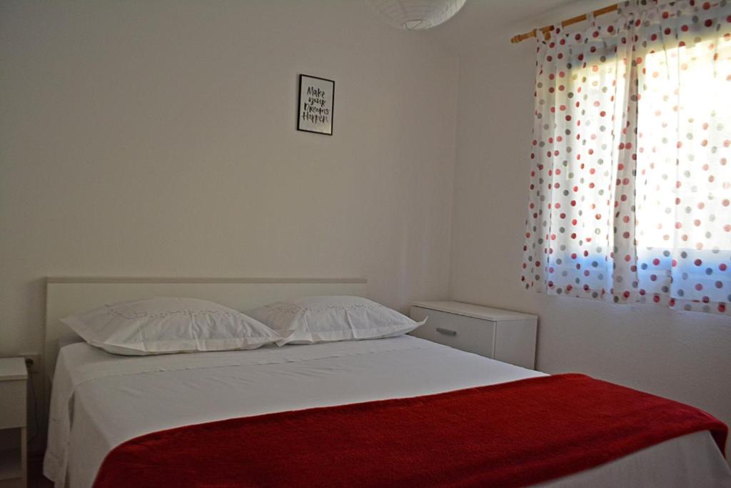 Un dormitorio con una cama con una manta roja. en Cosy Sunset Apartment en Omiš