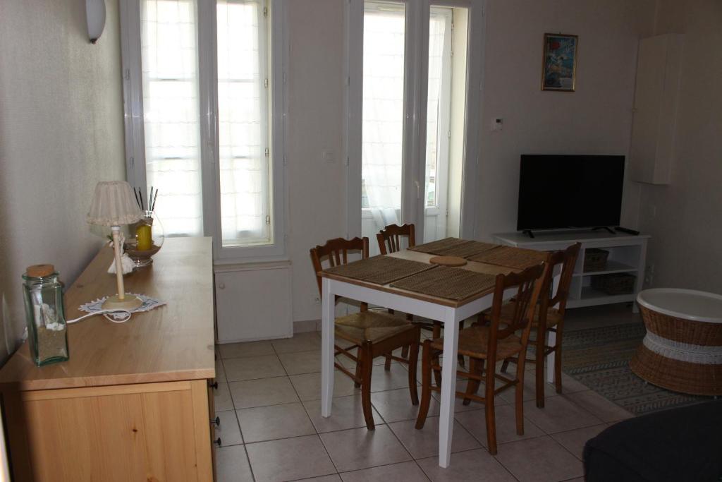 タルモンにあるmaison de bourgのキッチン(テーブル、椅子、テレビ付)