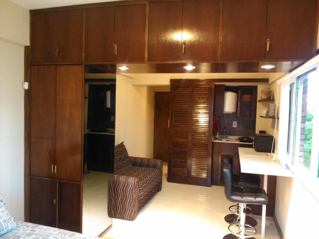 una pequeña cocina con armarios de madera y una silla en una habitación en Departamento Macro en Mendoza