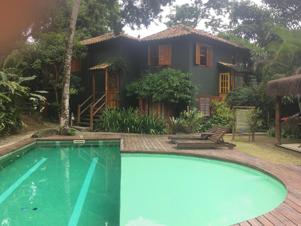 a house with a swimming pool in front of a house at Casa Condominio Acquaville Ilhabela in Ilhabela