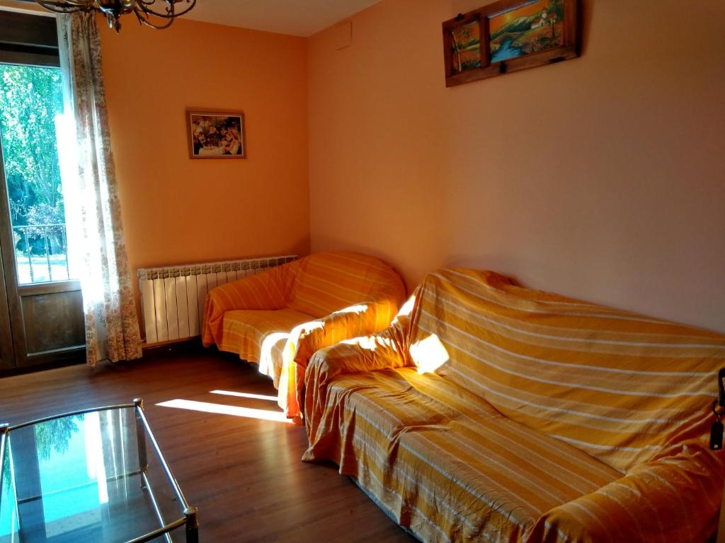 a living room with two couches and a glass table at Villaespina in Quintana del Puente