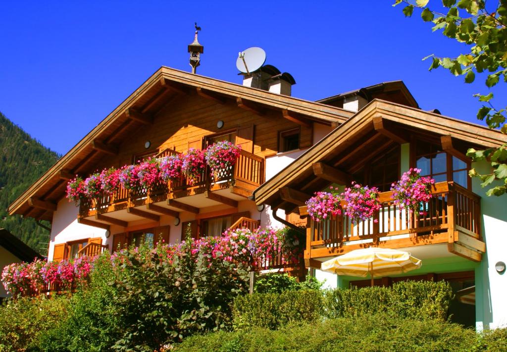 uma casa com flores na varanda em Residence Lagorai - Fiemme Holidays em Predazzo