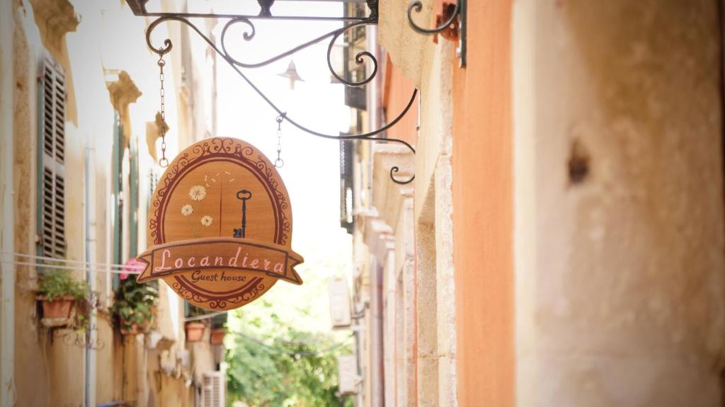 um sinal para um restaurante pendurado ao lado de um edifício em Locandiera em Corfu Town