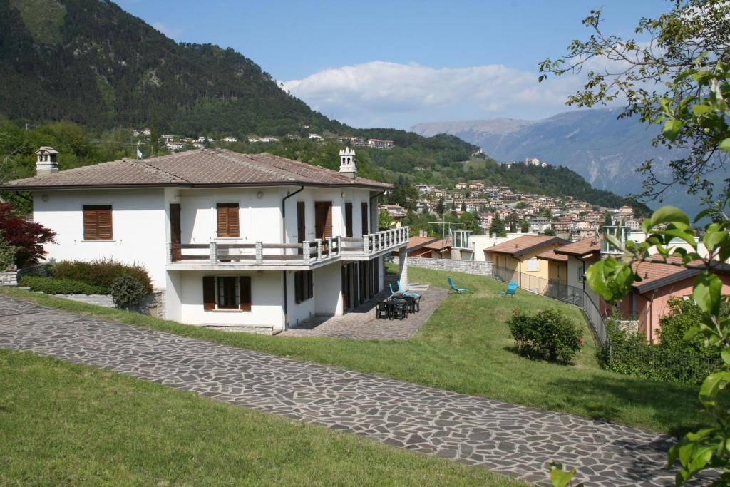 una casa su una collina con montagne sullo sfondo di La finestra sul Lago a Tignale