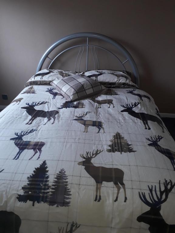a bed with a blanket with deer on it at Livingston Handy House in Livingston