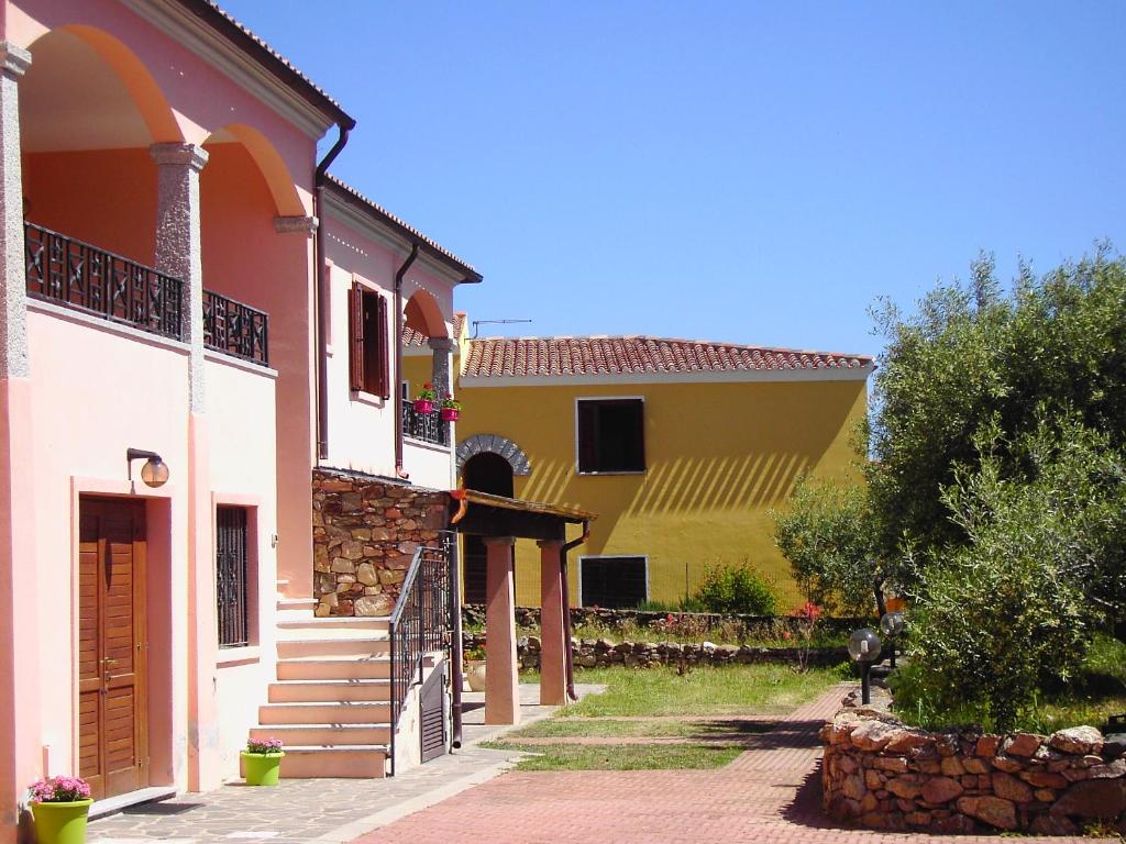 ブドーニにあるGli Uliviの階段と木のある黄白の家