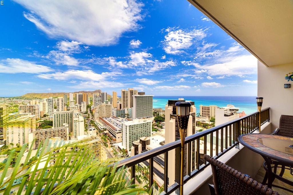 a balcony with a view of the city and the ocean at Central Waikiki Luxury Penthouse in Honolulu