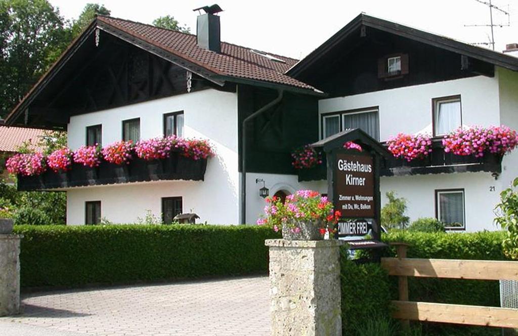 um edifício branco com caixas de flores e um sinal em frente em Gästehaus Kirner - Bad Feilnbach em Bad Feilnbach