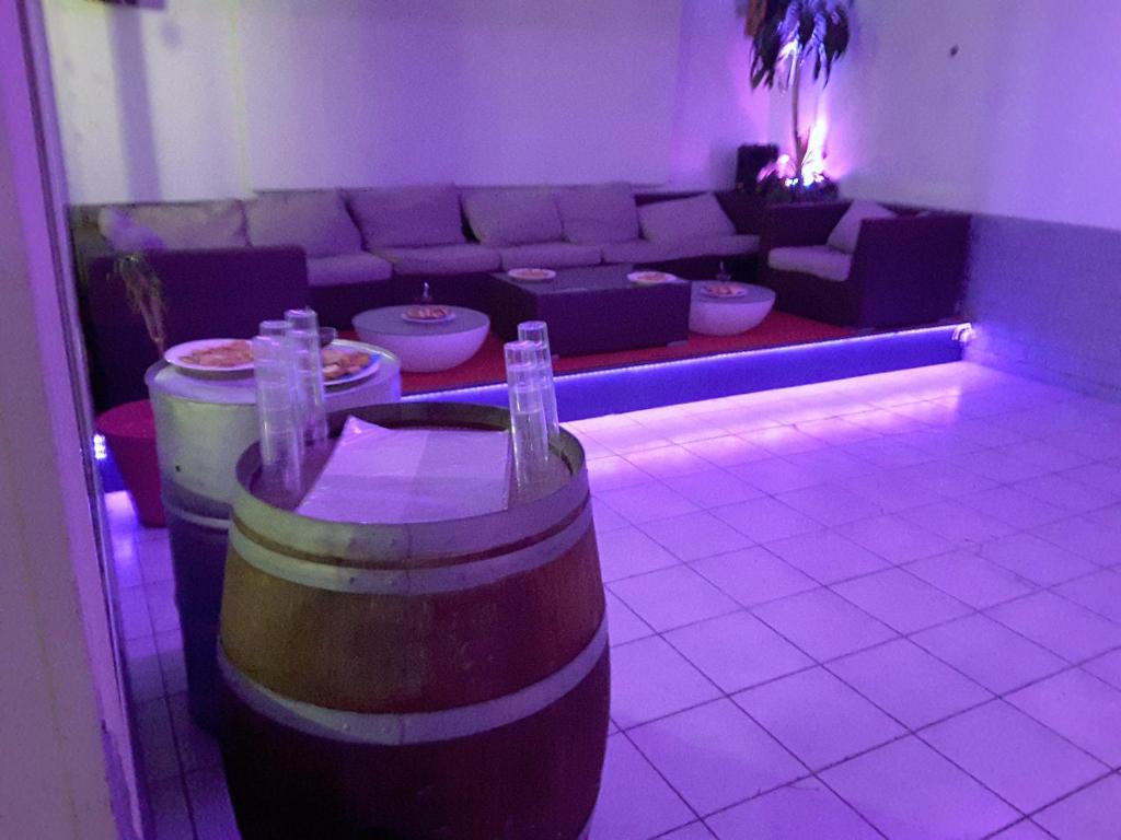 Habitación con sofá y mesa con barriles de vino. en Hotel Restaurant Calypso, à 10 m de la plage en Fos-sur-Mer
