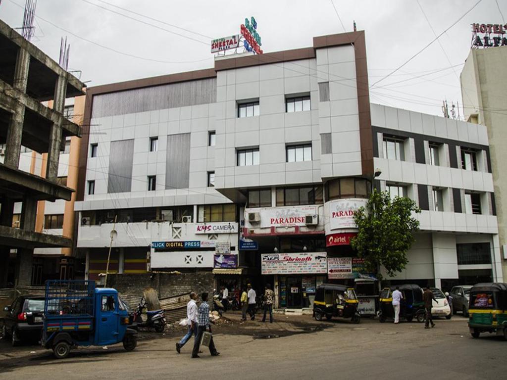 een groot gebouw waar mensen voor lopen bij Hotel Sheetal Plaza in Surat