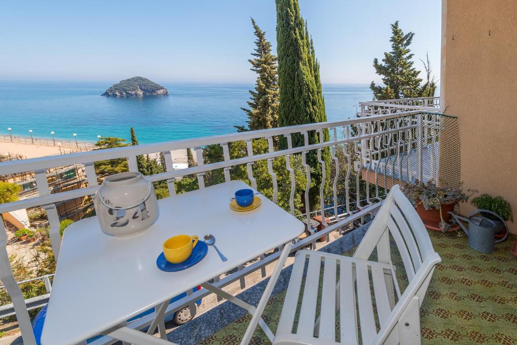 una mesa en un balcón con vistas al océano en Golfo dell'Isola Appartamento, en Spotorno