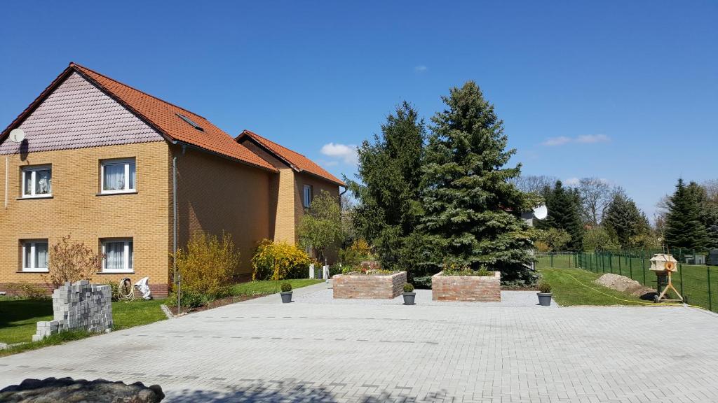 ein Haus mit einem Baum vor einer Einfahrt in der Unterkunft FeWo Schütz in Langewahl