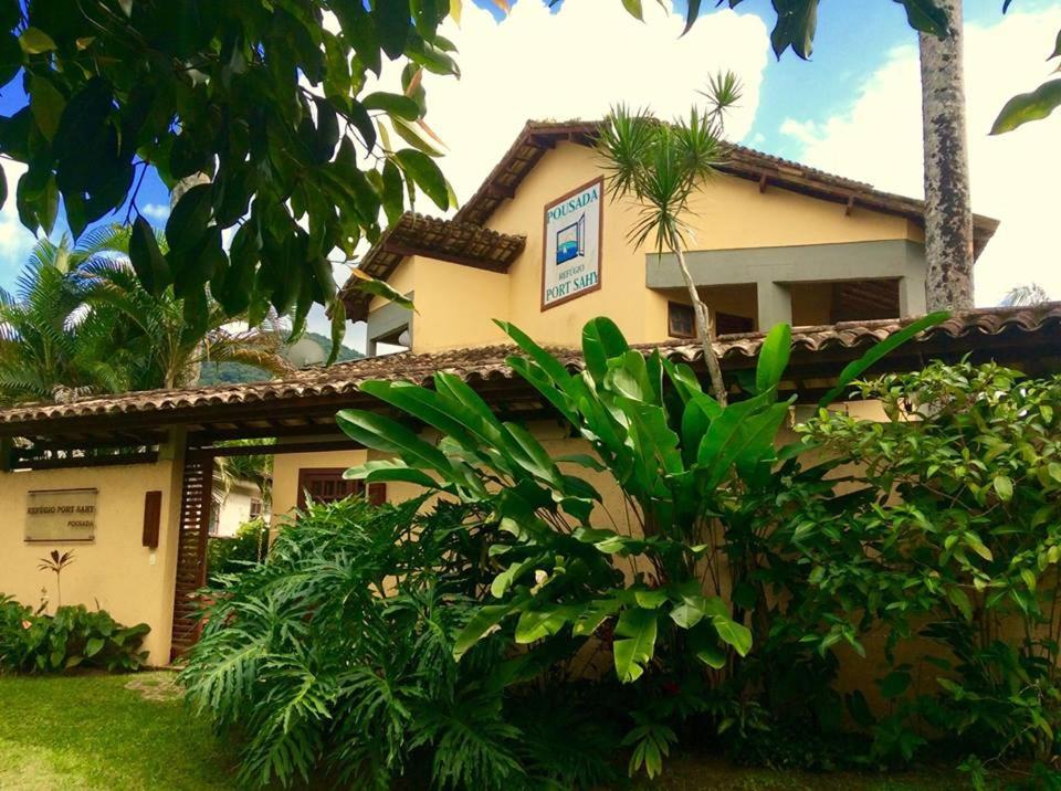 a building with a bunch of trees in front of it at Pousada Refugio Port Sahy in Barra do Sahy