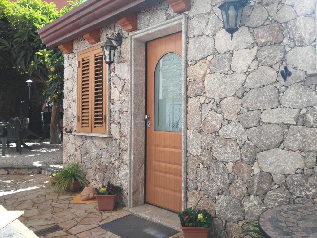 a stone house with a door and a stone wall at Giardino Del Sole in Taormina