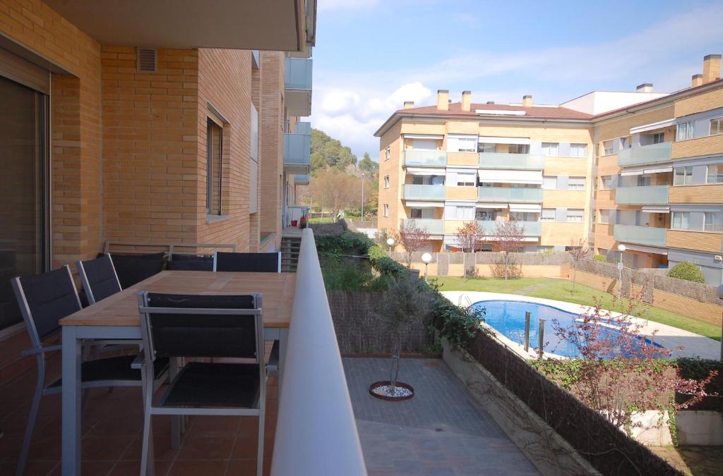 uma varanda com uma mesa e cadeiras e uma piscina em Lets Holidays Apartment Vinya del Pla em Tossa de Mar