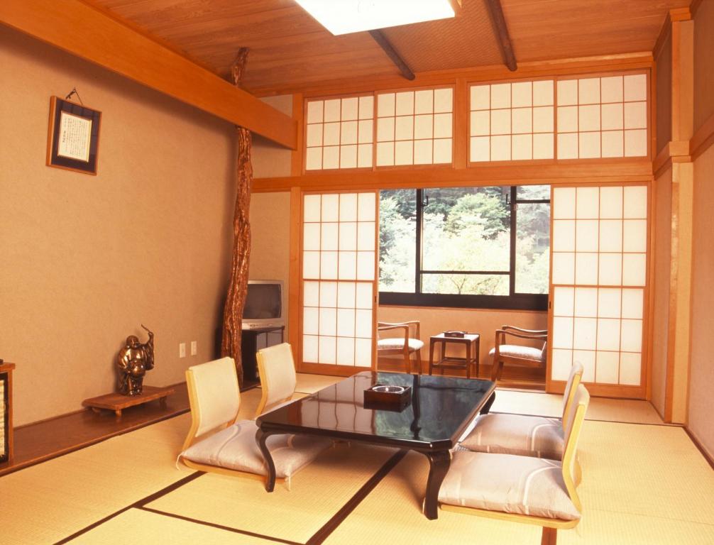 a living room with a table and chairs at Takaragawa Onsen Ousenkaku in Minakami