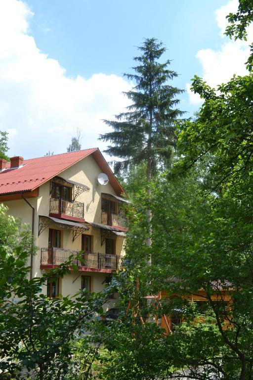 a building with balconies and trees in the foreground at Hovanka in Yaremche