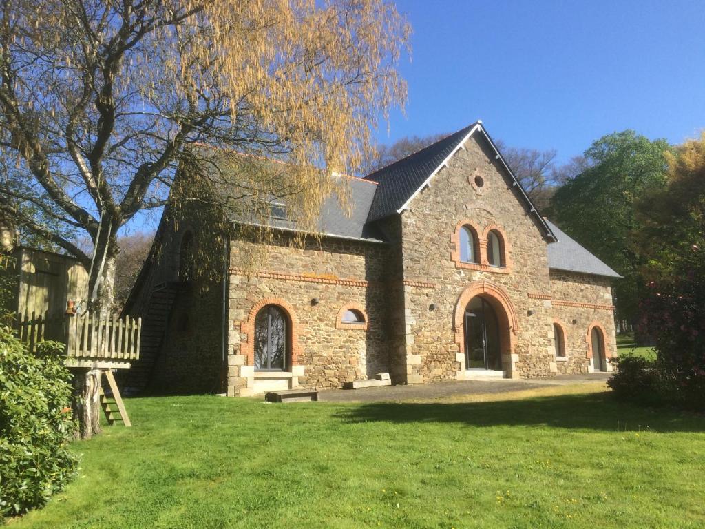 an old brick church with a bench in the yard at La Chambre Montbrault in Fleurigné