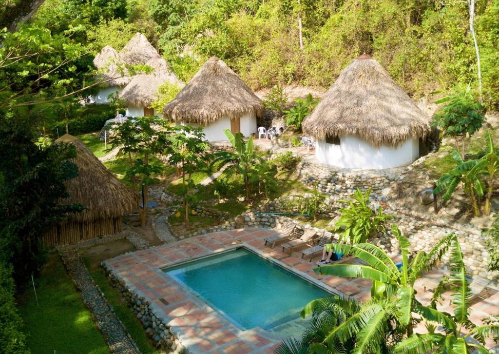ein Bild eines Resorts mit Pool und Hütten in der Unterkunft Finca Carpe Diem Ecolodge in Minca