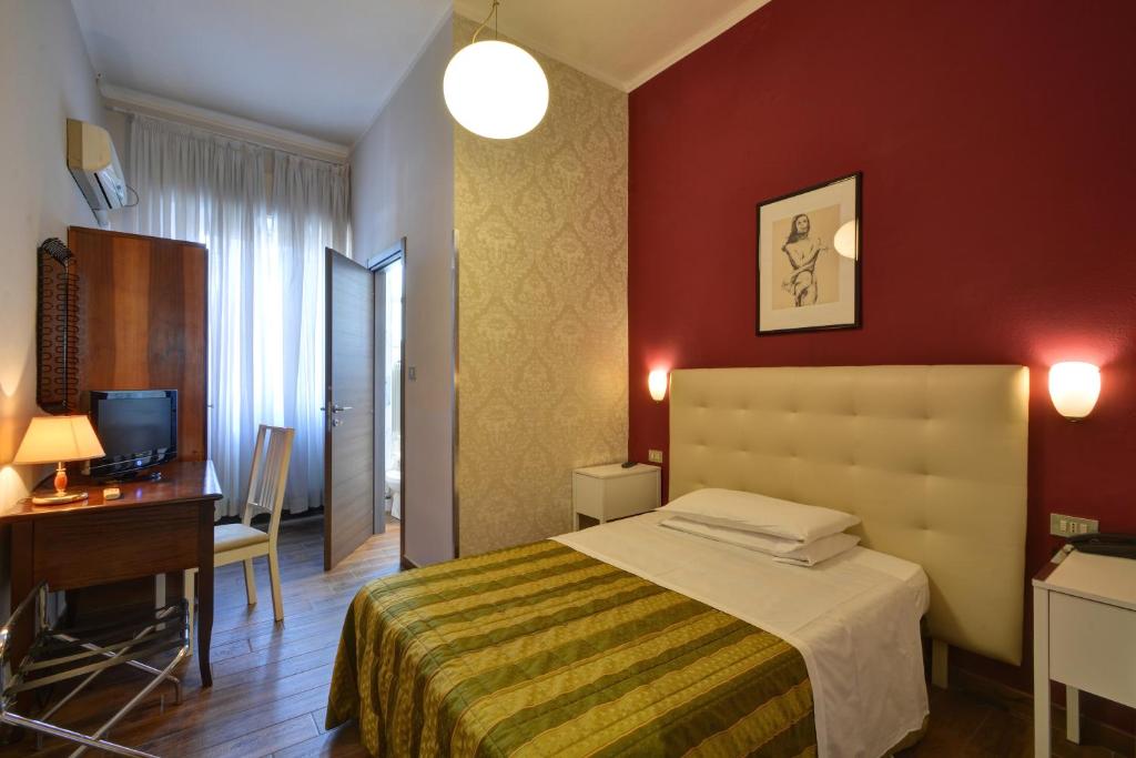 ein Hotelzimmer mit einem Bett, einem Schreibtisch und einem Computer in der Unterkunft Hotel Universo in Turin