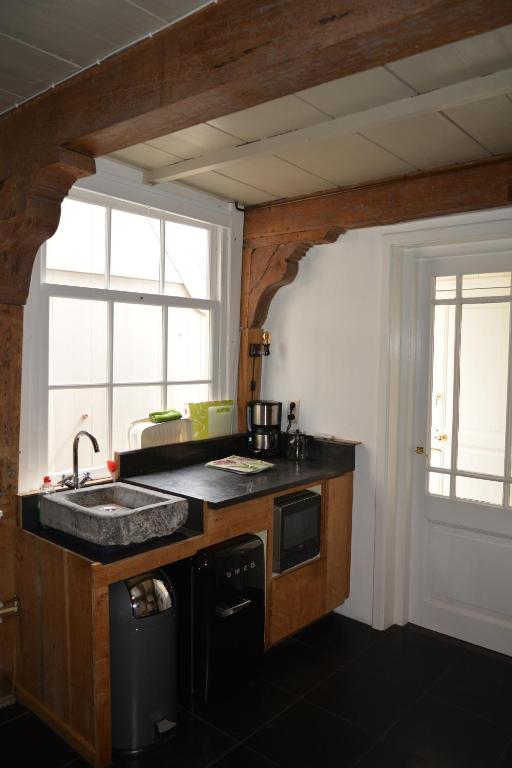une cuisine avec un évier et une fenêtre dans l'établissement Waterland Achterhuis, à Monnickendam