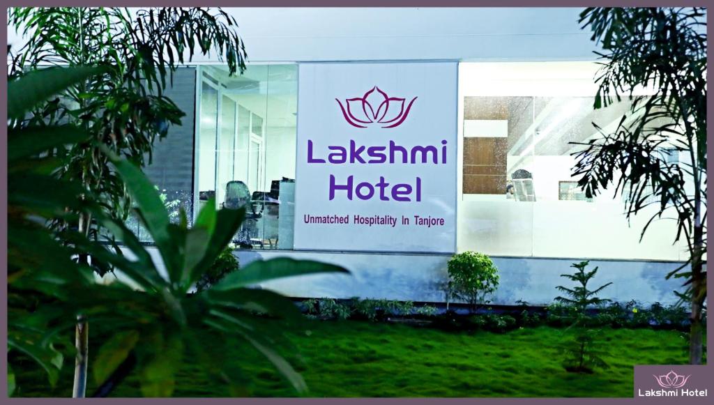 um sinal para um hotel laxantis na lateral de um edifício em Lakshmi Hotel em Thanjavur