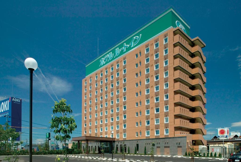 un grand bâtiment avec un panneau en haut dans l'établissement Hotel Route-Inn Koriyama Minami, à Koriyama