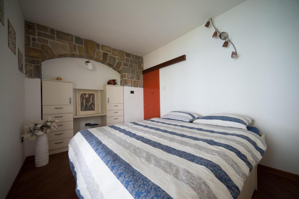 1 dormitorio con cama de rayas azul y blanco en Fiesa-Piran beach house with free parking, en Piran