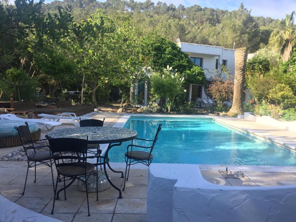 eine Terrasse mit einem Tisch und Stühlen neben einem Pool in der Unterkunft Can Iara in Sant Miquel de Balansat