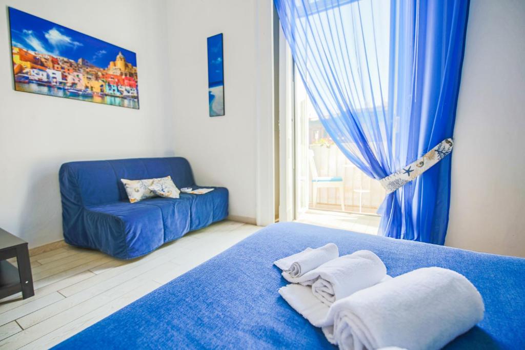 Bed & Breakfast Piazza Dante في نابولي: غرفة نوم بسرير ازرق واريكة زرقاء