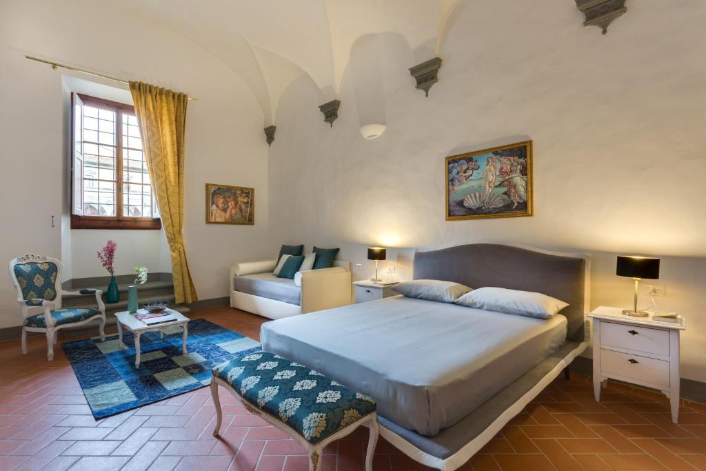 una camera con un grande letto e un divano di Residenza d'Epoca Galleria dell'Accademia a Firenze