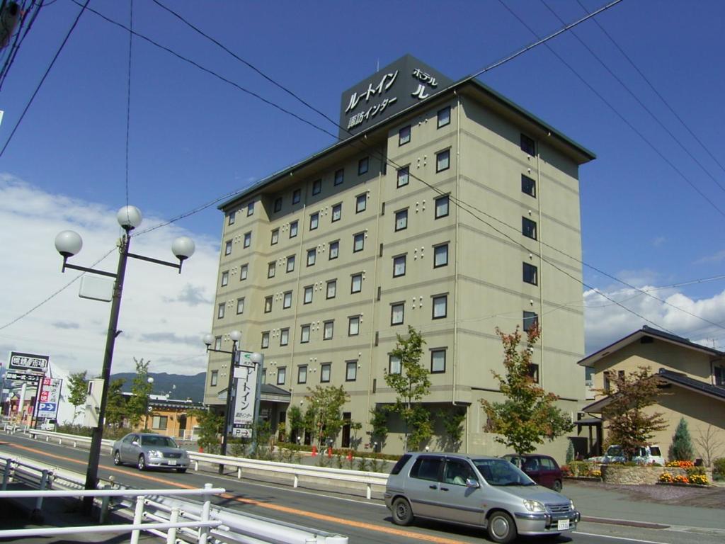 un gran edificio con un cartel encima en Hotel Route-Inn Suwa Inter, en Suwa